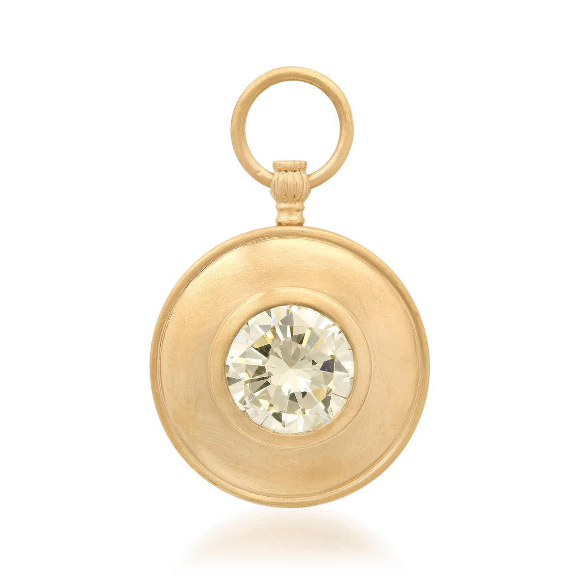 A round gold pendant with a textured brushed finish, featuring a bezel-set clear round gemstone in the center and a small top loop, shown on a white background.