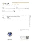 A GIA certification report page with form fields, a GIA logo at the top left, a round blue gemstone specimen photo near the bottom center, and a small certificate seal at the bottom right on a white background.