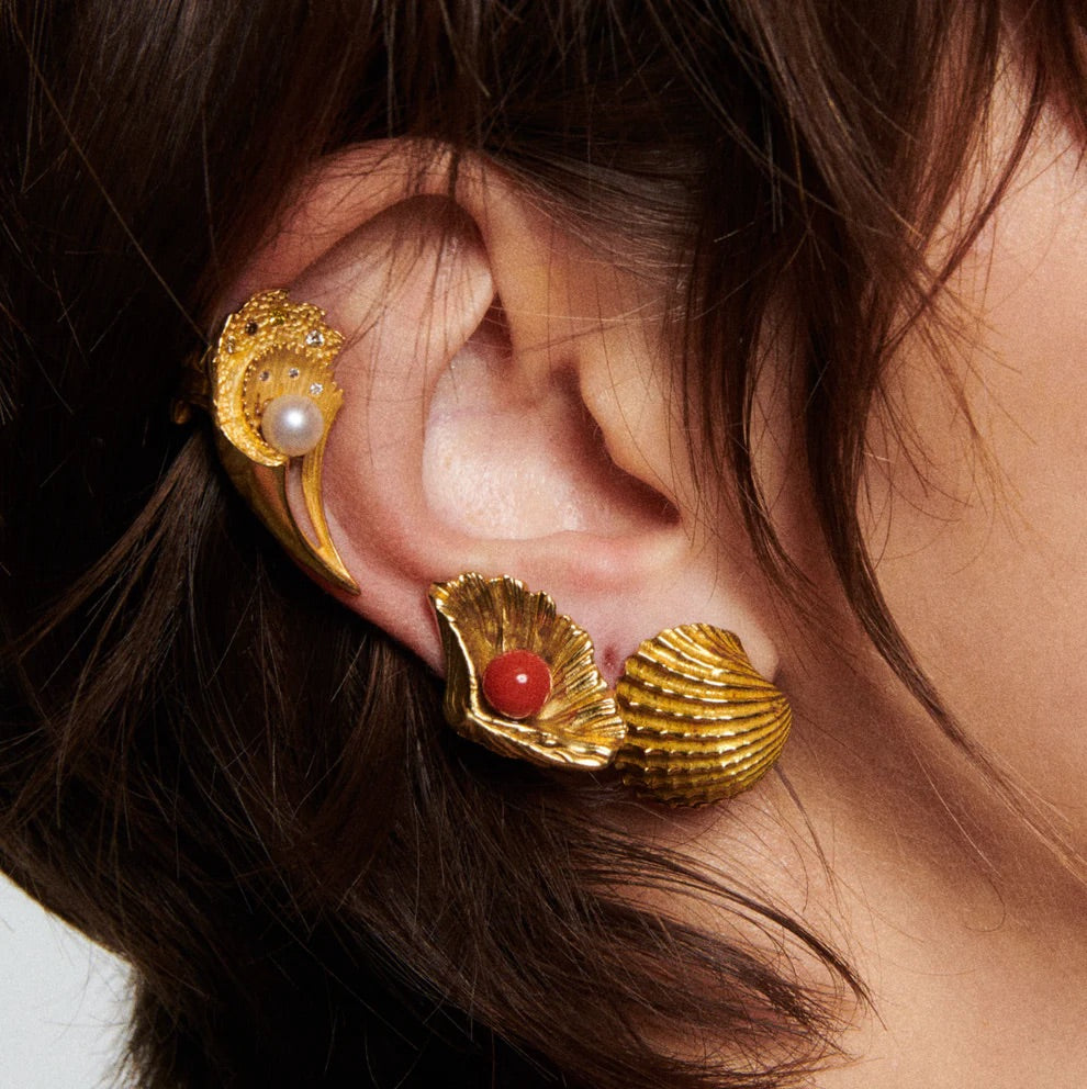 Model wearing Conchiglia shell earrings in 18K yellow gold