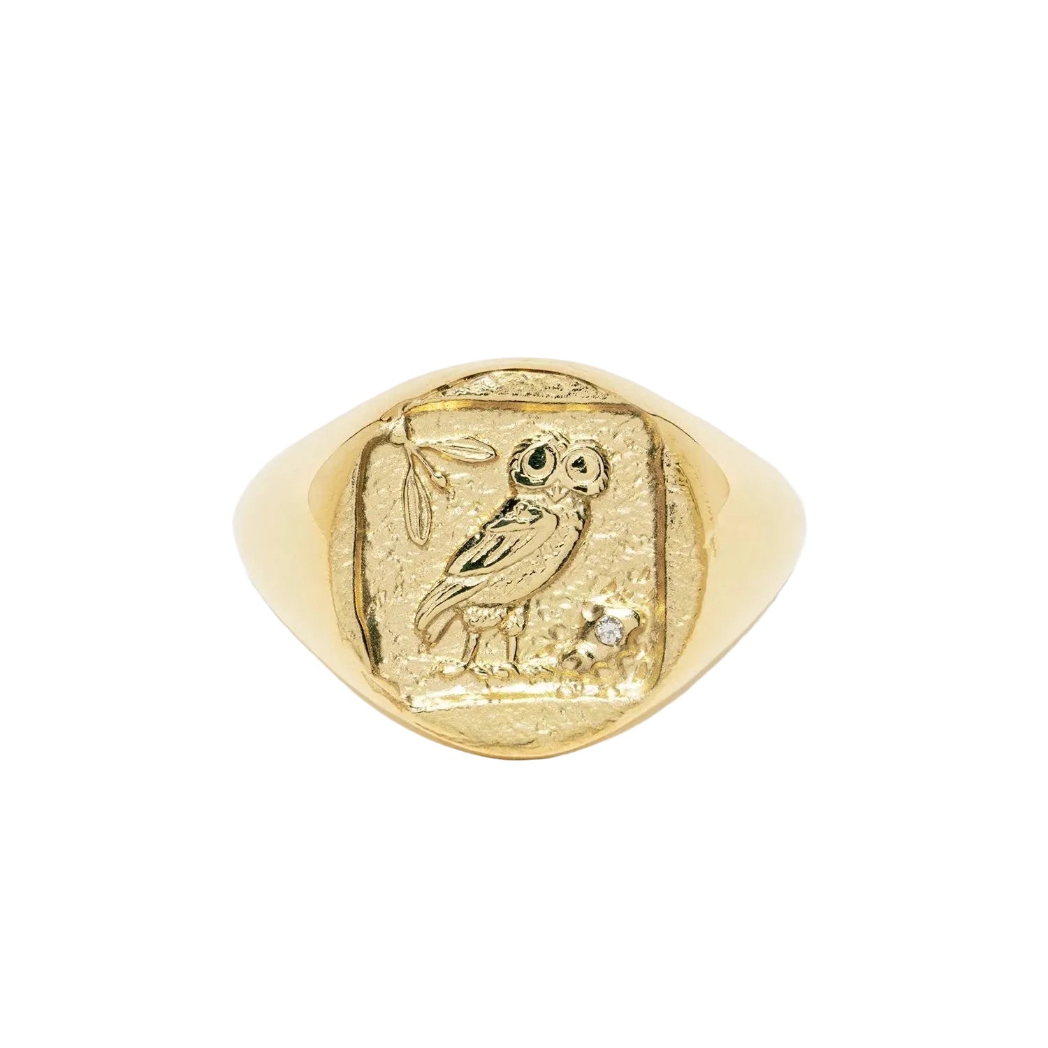 A gold signet ring featuring an embossed owl motif on a textured face, accented with a small clear gemstone, shown on a clean white background.