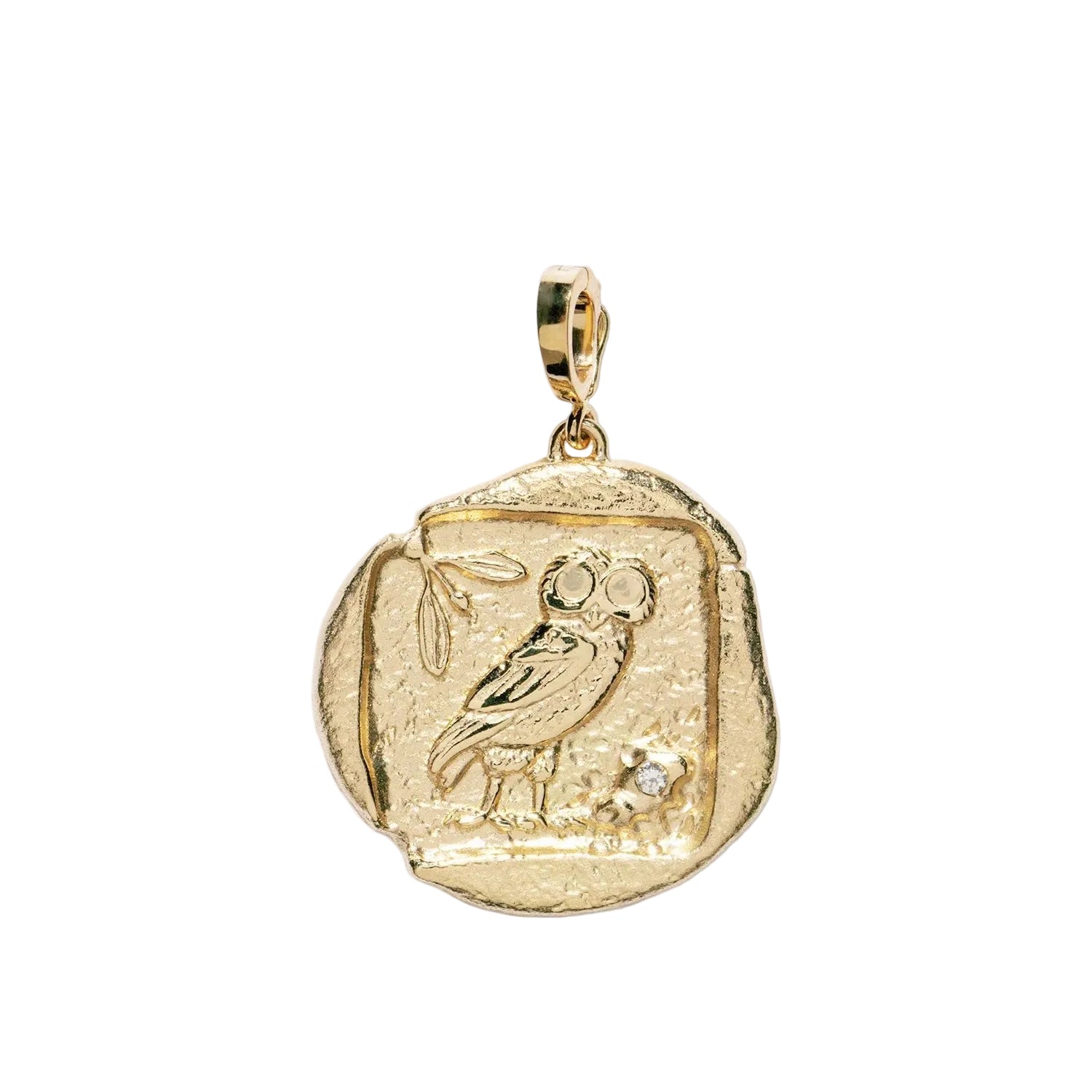 A gold pendant shaped like a textured ancient coin, featuring an engraved bird design and a small clear stone, shown on a light gray background.