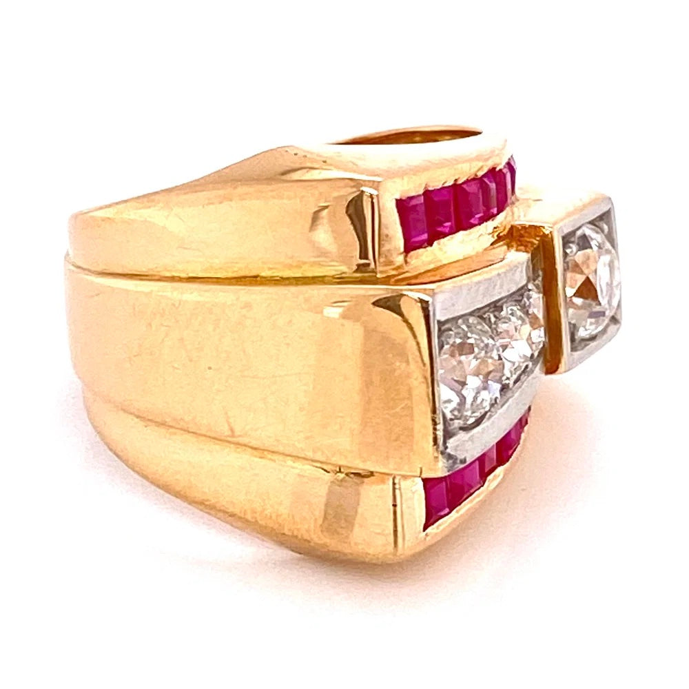 A gold signet-style ring featuring a large clear round diamond and smaller round diamonds, accented with bright pink gemstones on a white background.