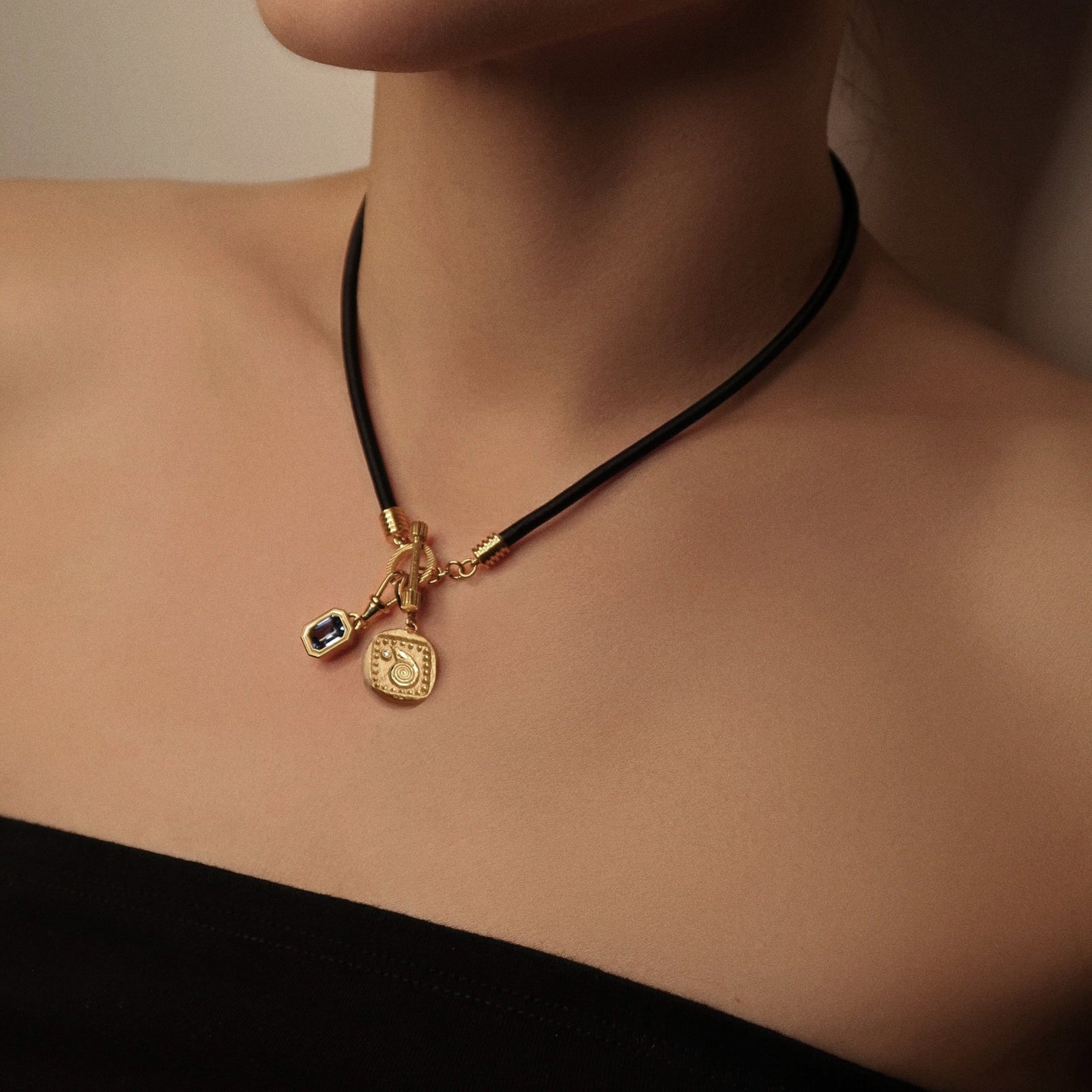 Model wearing spiral seashell diamond charm on gold chain