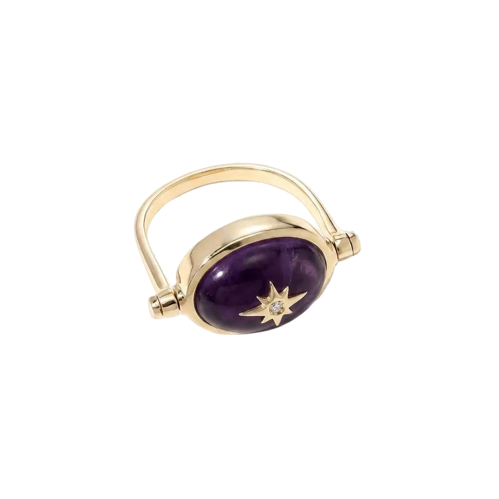 Gold ring with a purple gemstone and star-shaped diamond on a white background