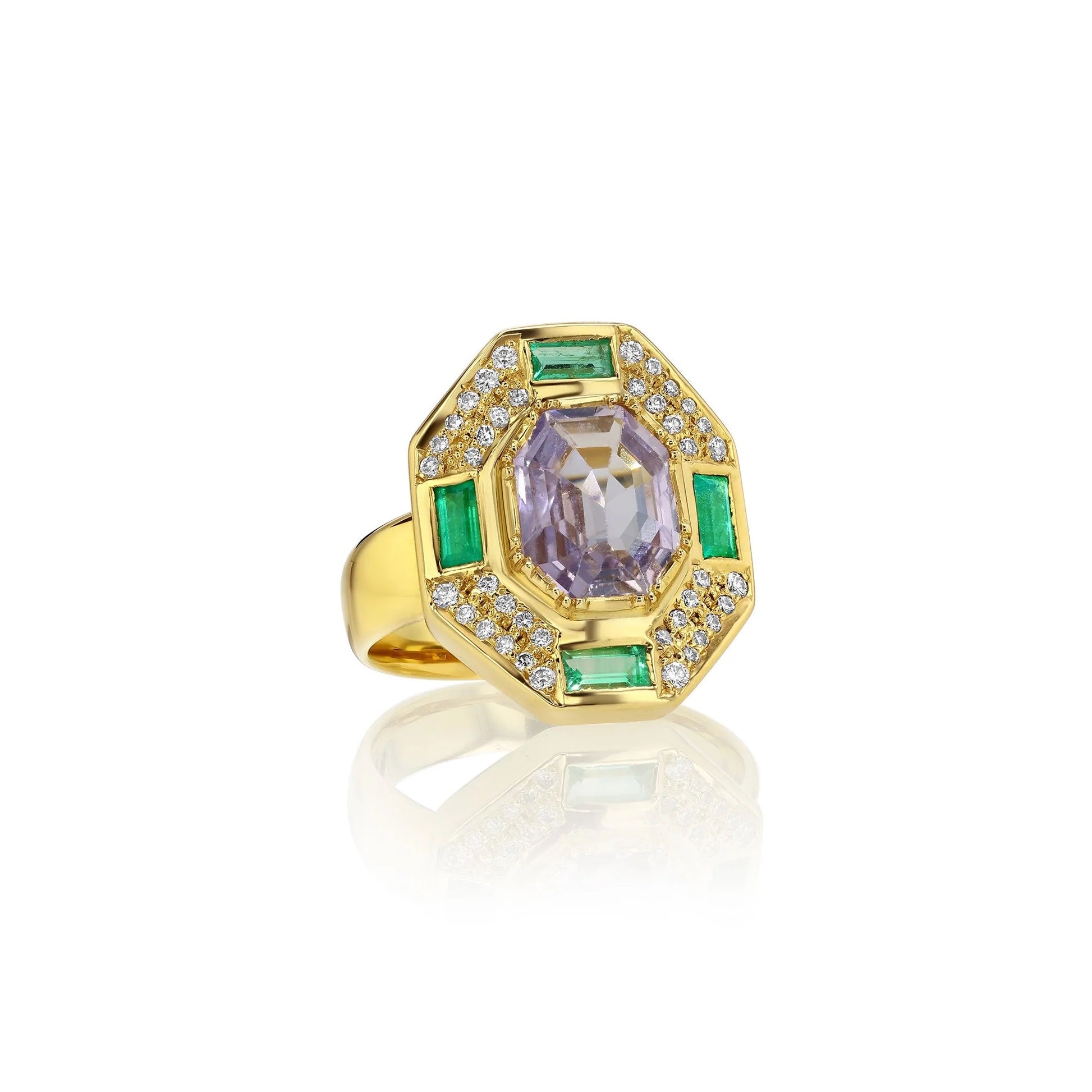 Gold ring with a purple gemstone and green accents on a white background