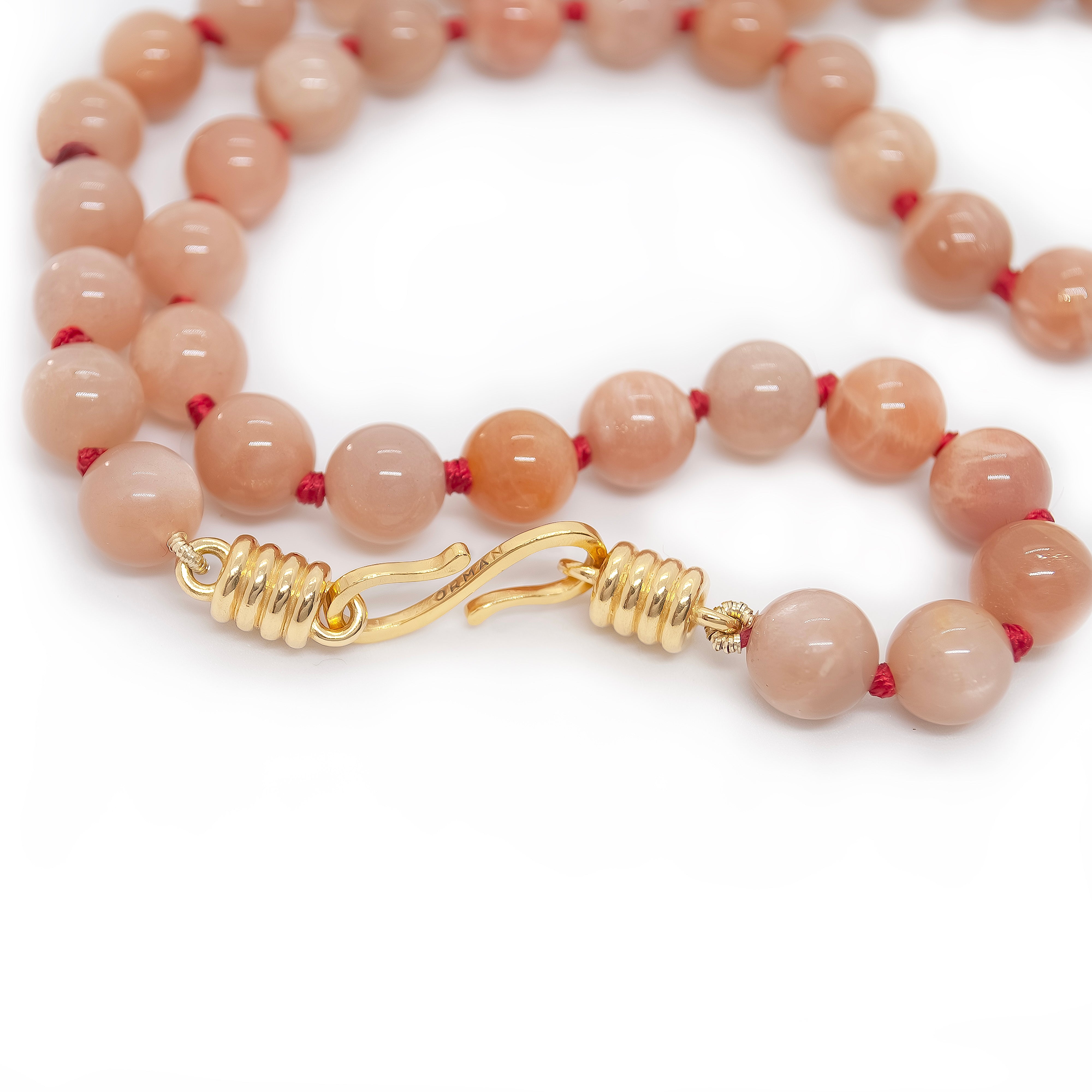 pink beaded necklace on white background