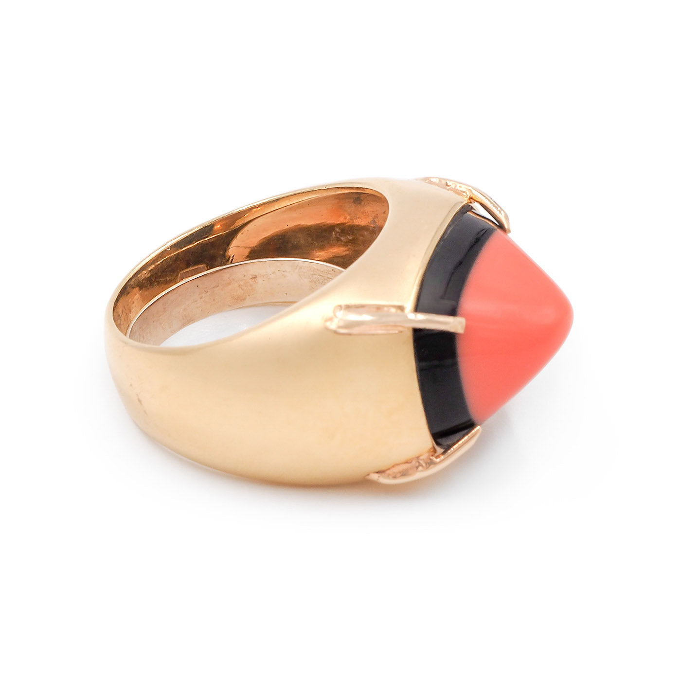 Gold ring with a pink and black gemstone on a white background