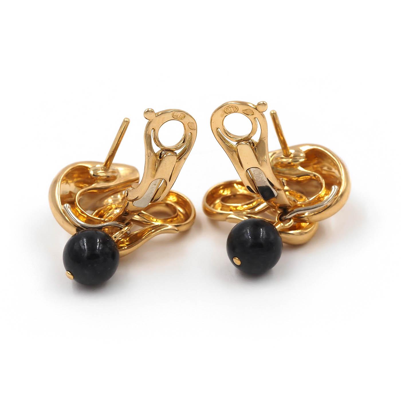 Gold earrings with black beads on a white background