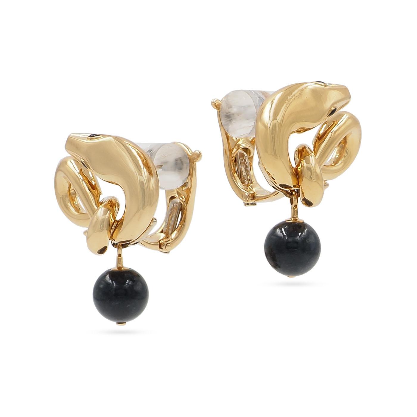 Gold earrings with clear and black stones on a white background