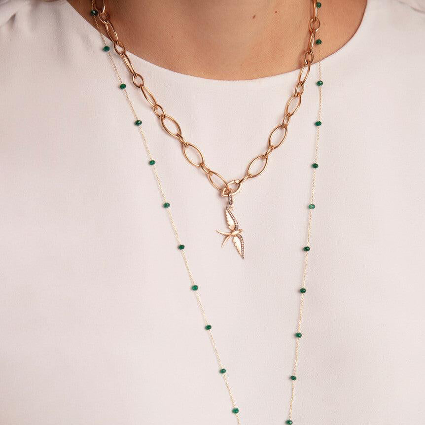 Necklace with starfish pendants and green beads on a plain background