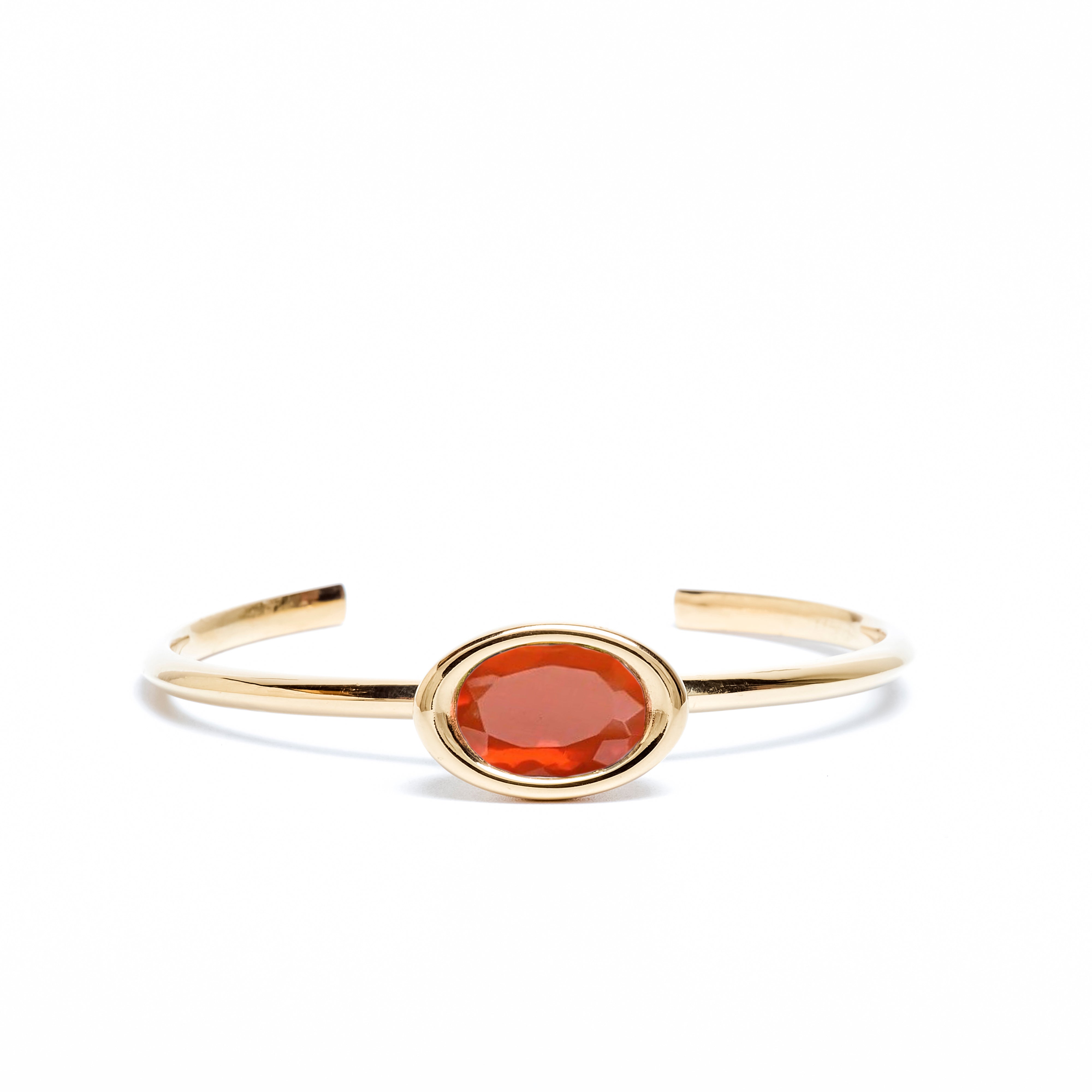 Gold bracelet with a red stone on a white background