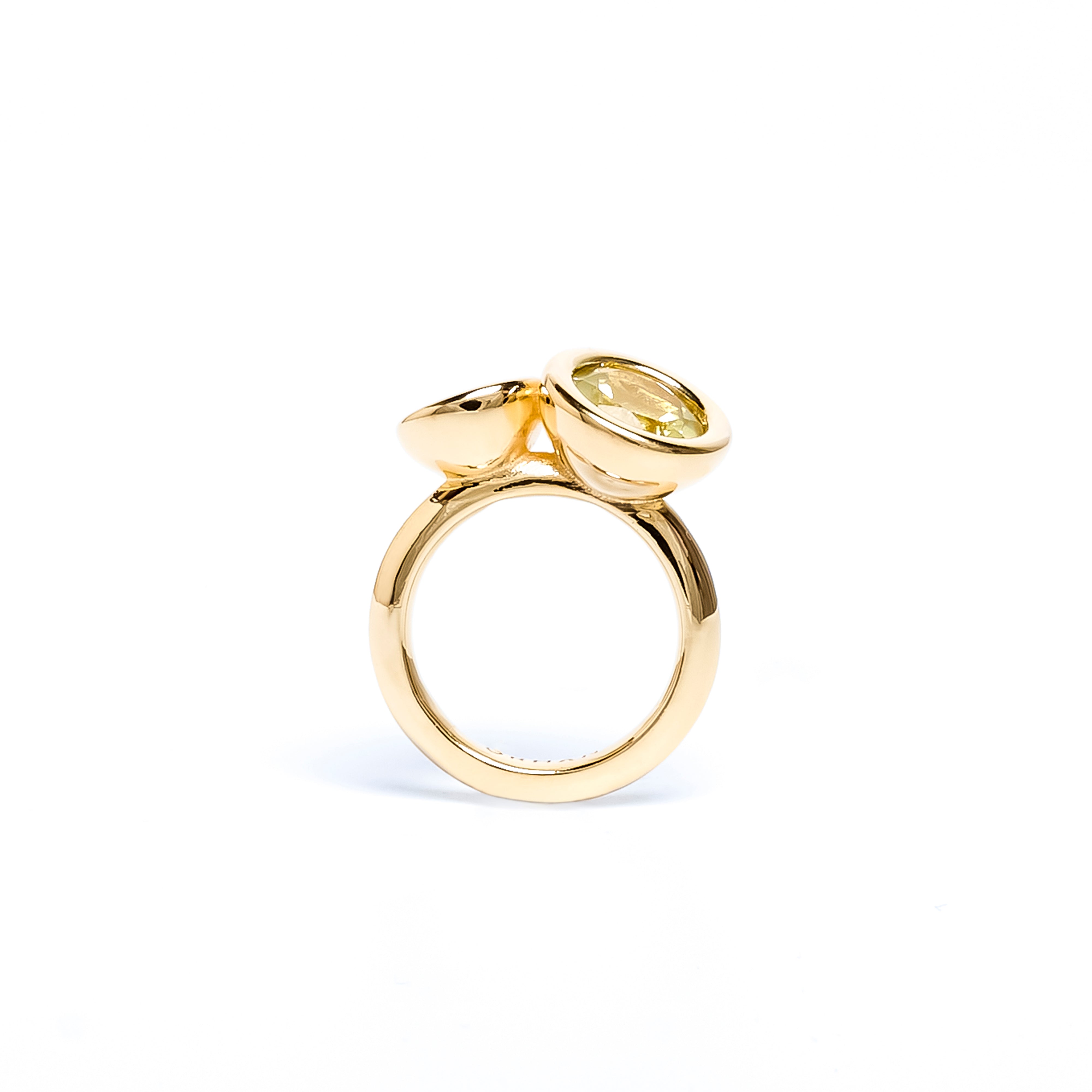 Gold ring with a yellow gemstone on a white background