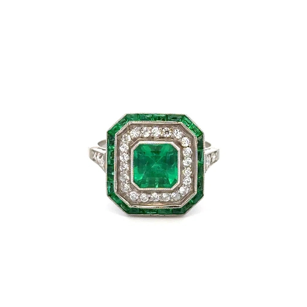 Ring with emerald and diamond accents on a white background