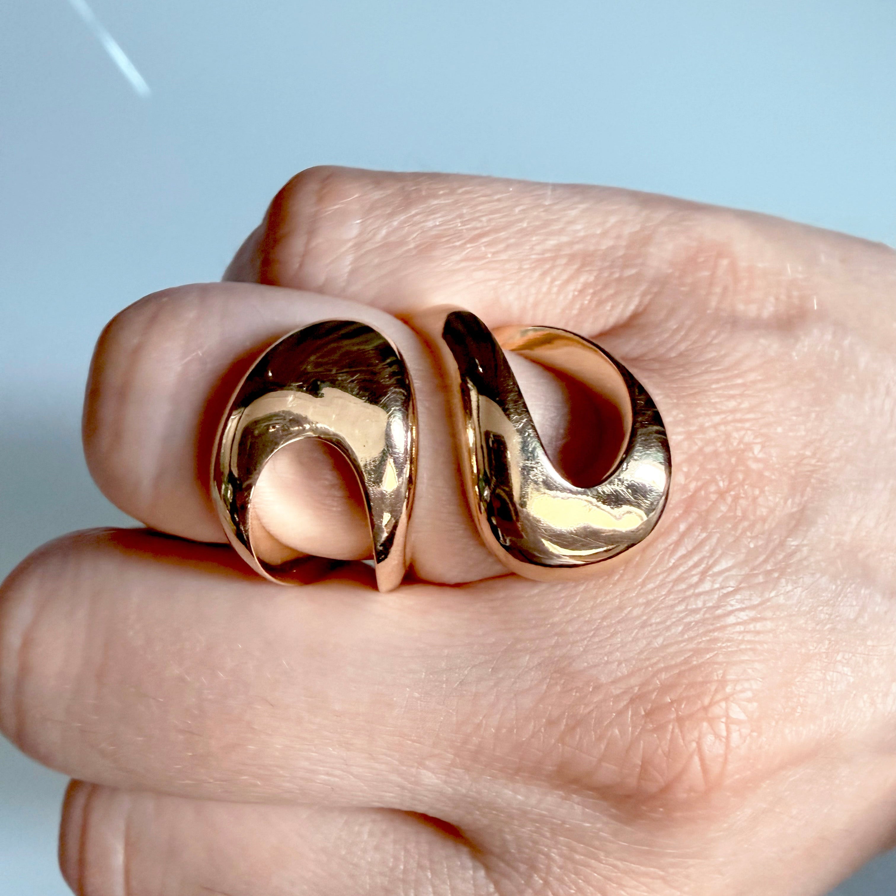 Gold ring on a hand against a light background