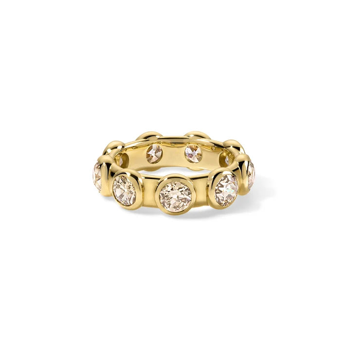 A gold eternity-style ring featuring multiple bezel-set round clear gemstones, photographed on a clean white background.
