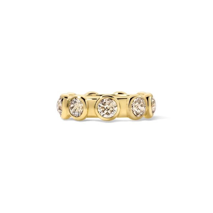 A yellow gold band ring featuring three round-cut clear gemstones in a row, set against a plain white background.