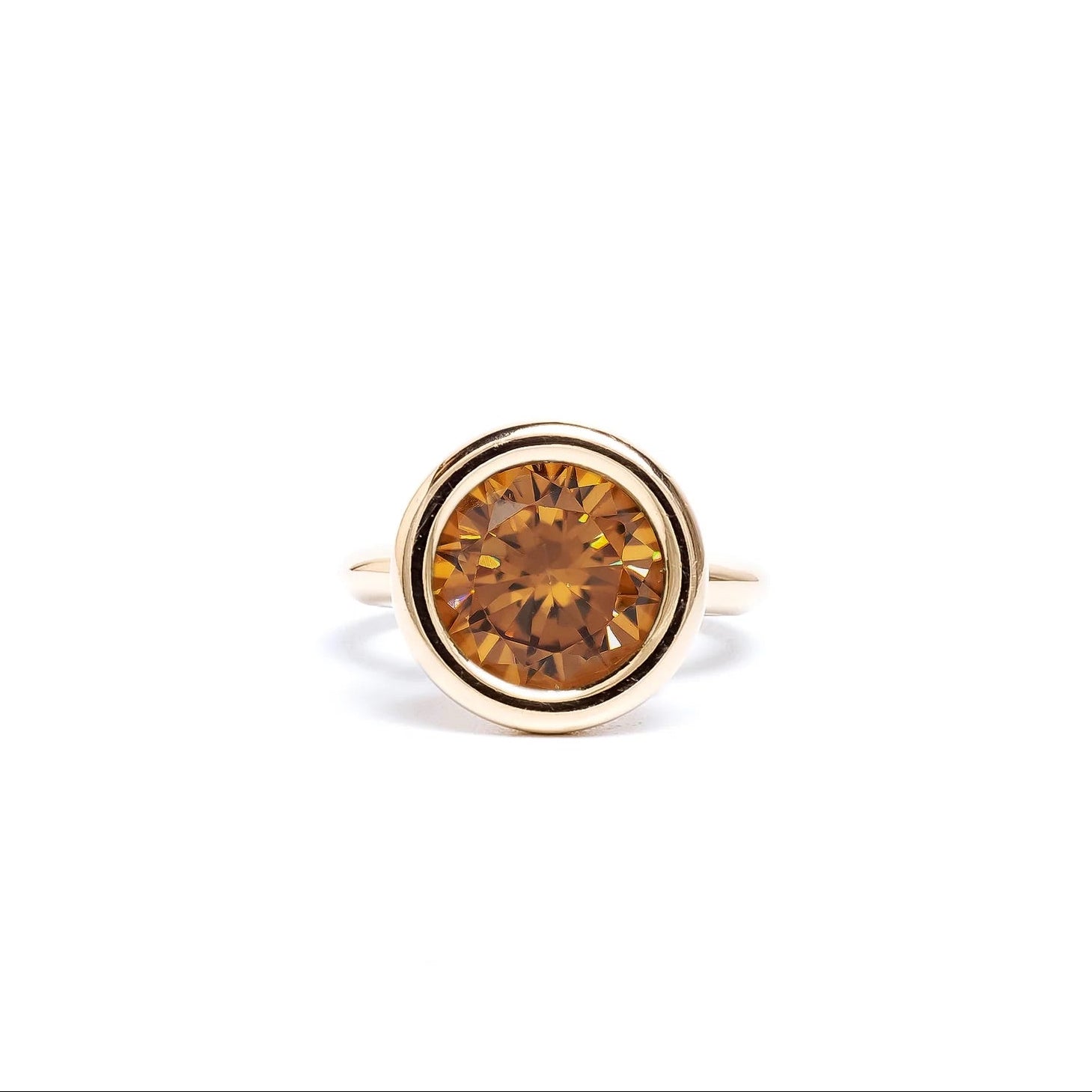Gold ring with a brown gemstone on a white background