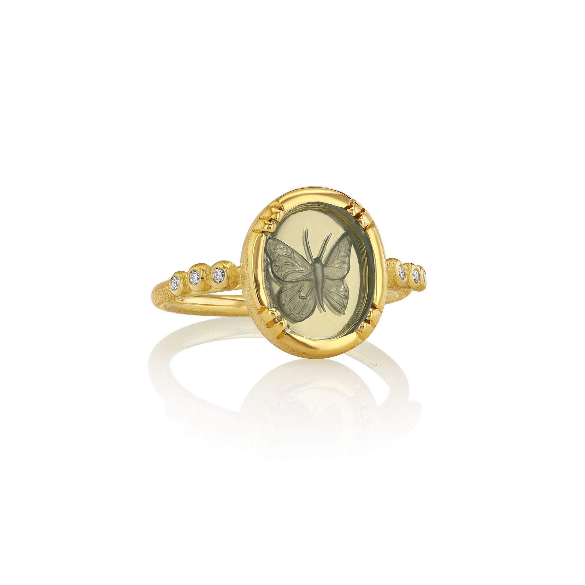 Gold ring with butterfly design on a white background