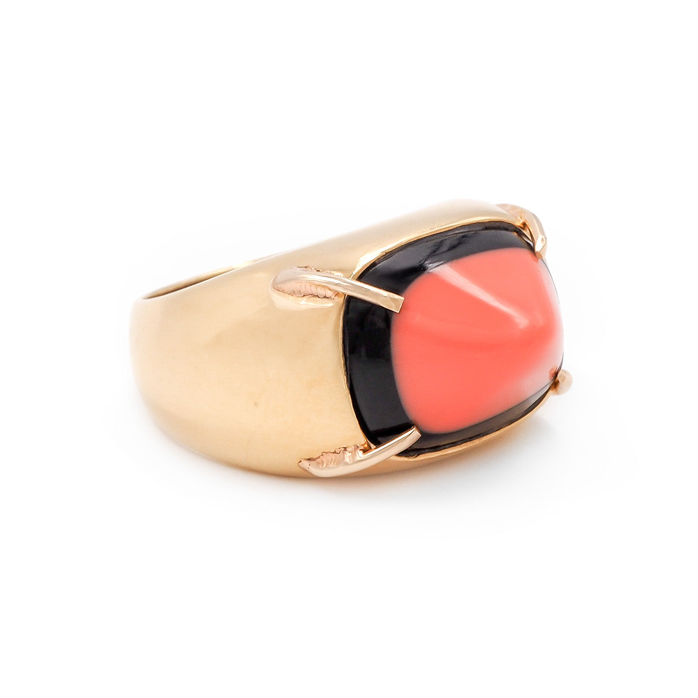 Gold ring with a black and coral stone on a white background