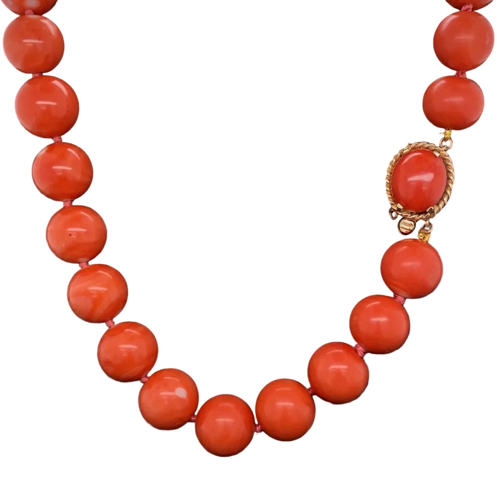 Necklace with red beads and a gold clasp on a black background