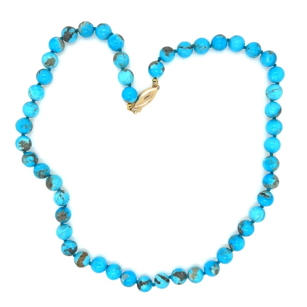 Turquoise beaded necklace with a gold clasp on a white background
