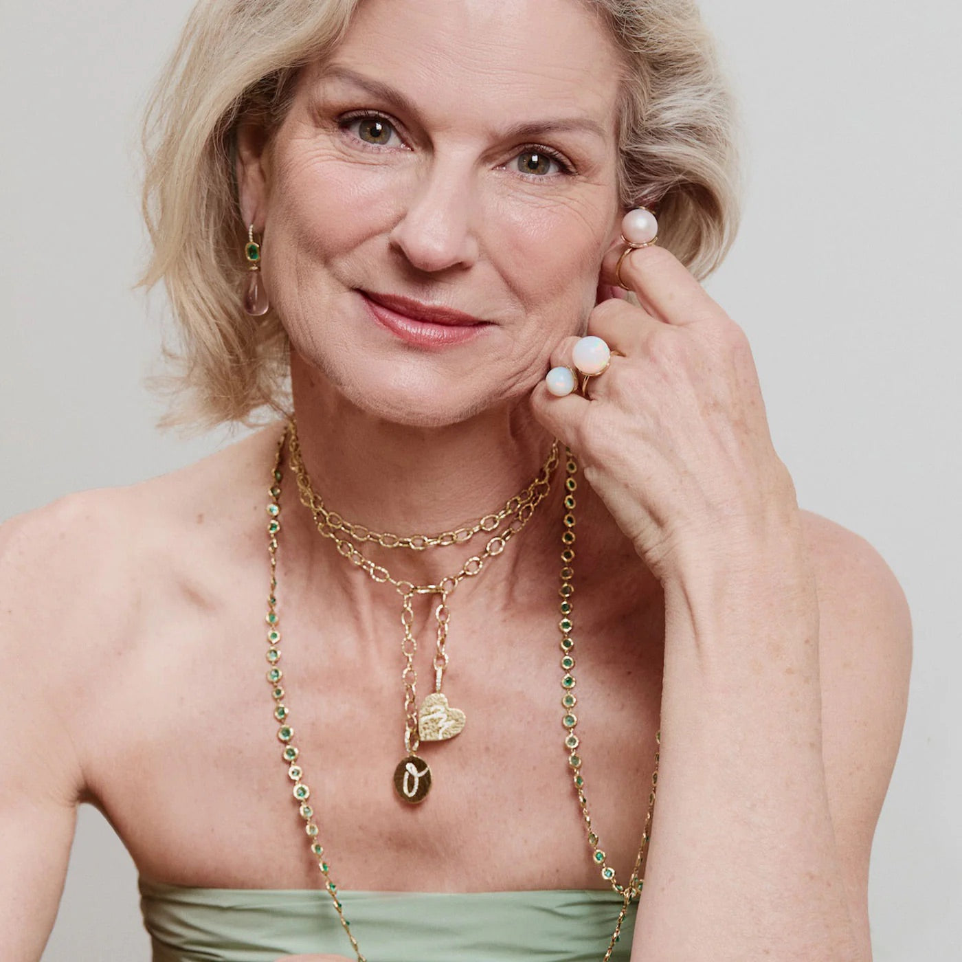 Woman wearing gold jewelry with a plain background
