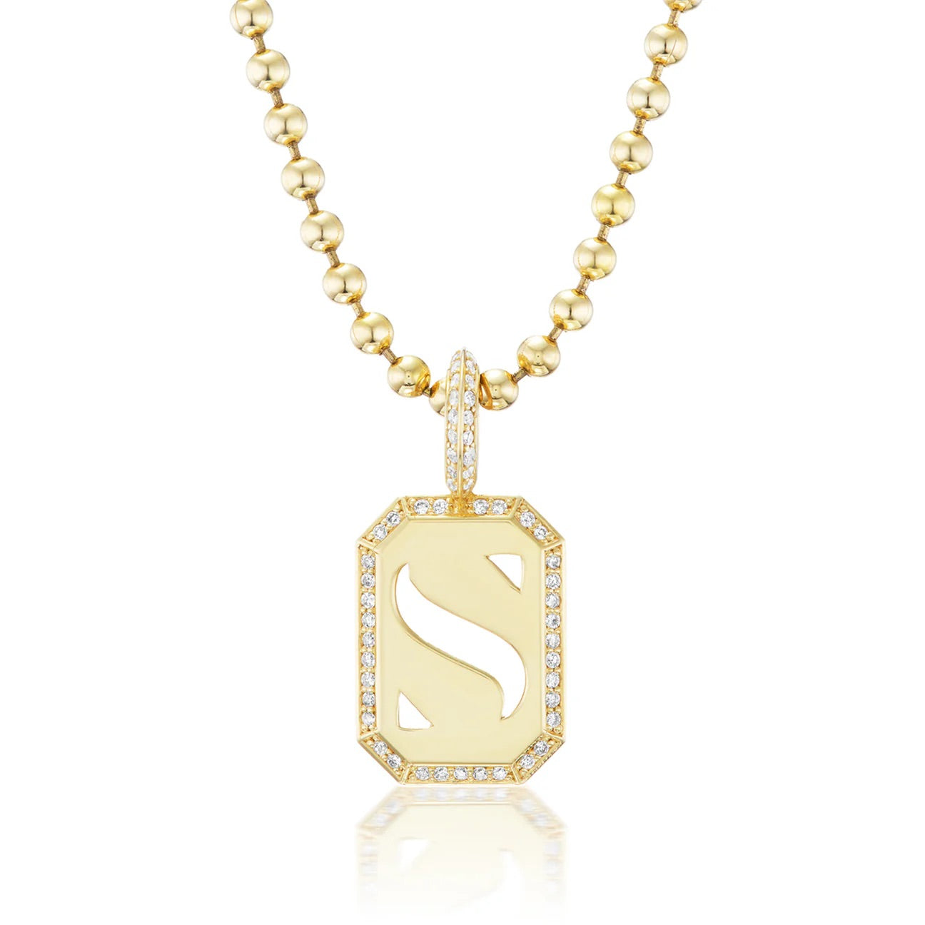 Gold necklace with a pendant featuring a stylized letter 'S' on a white background