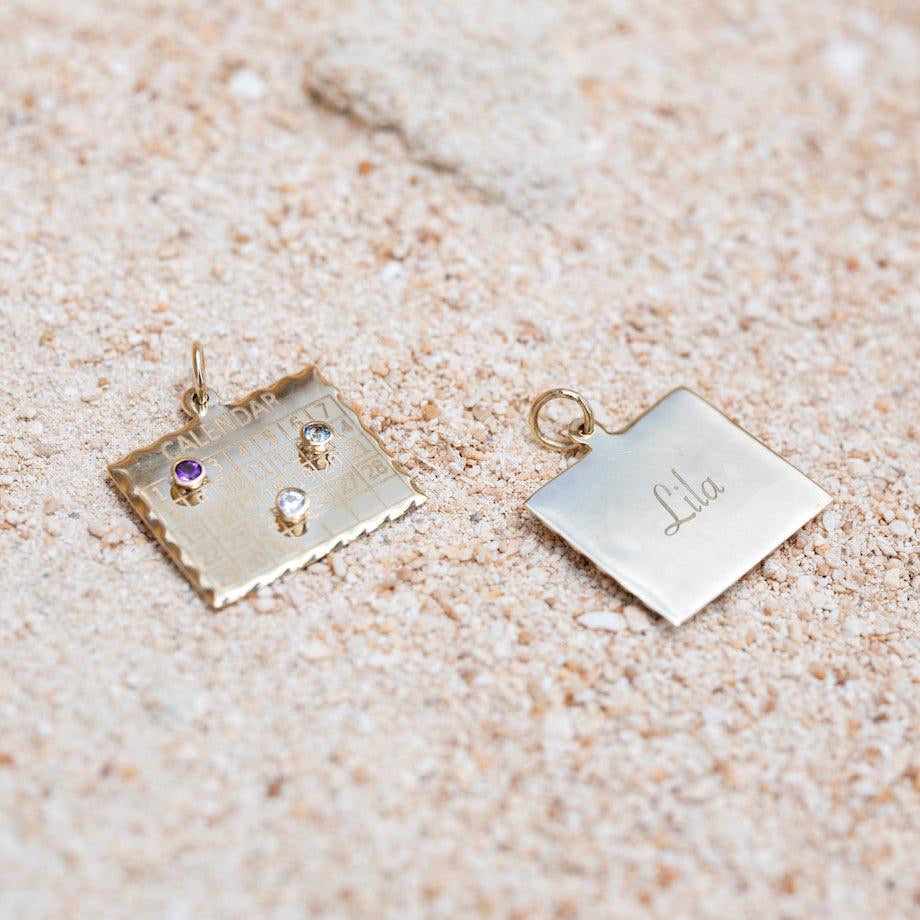 Gold jewelry with embedded stones on a textured beige surface