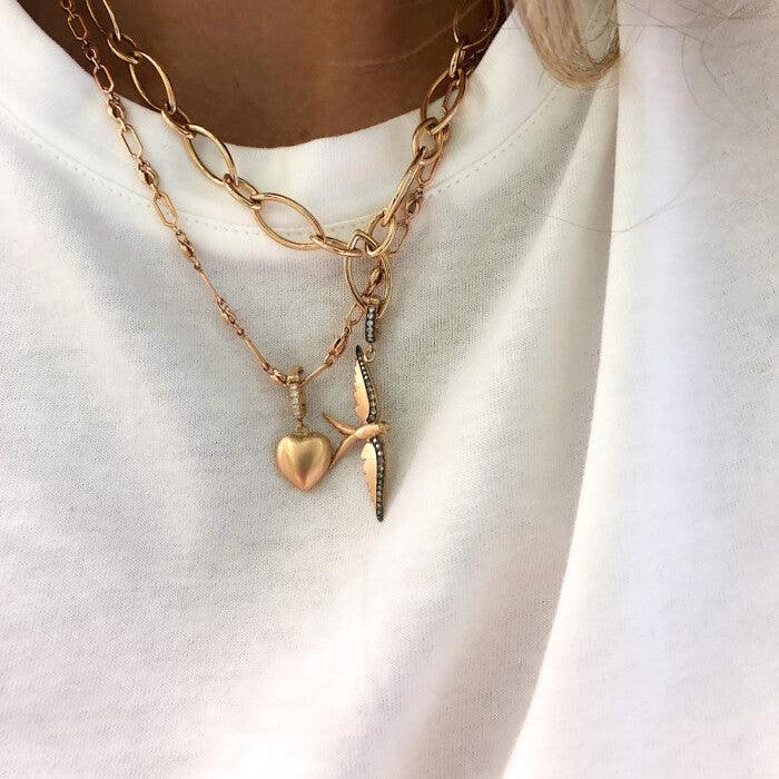 Layered gold necklaces with heart and starfish pendants on a white background